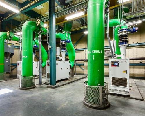 Large green pipes inside the facility and other controls/equipment.